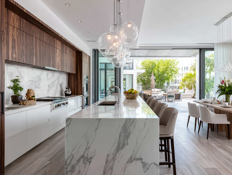 Modern kitchen with marble island and glass pendants